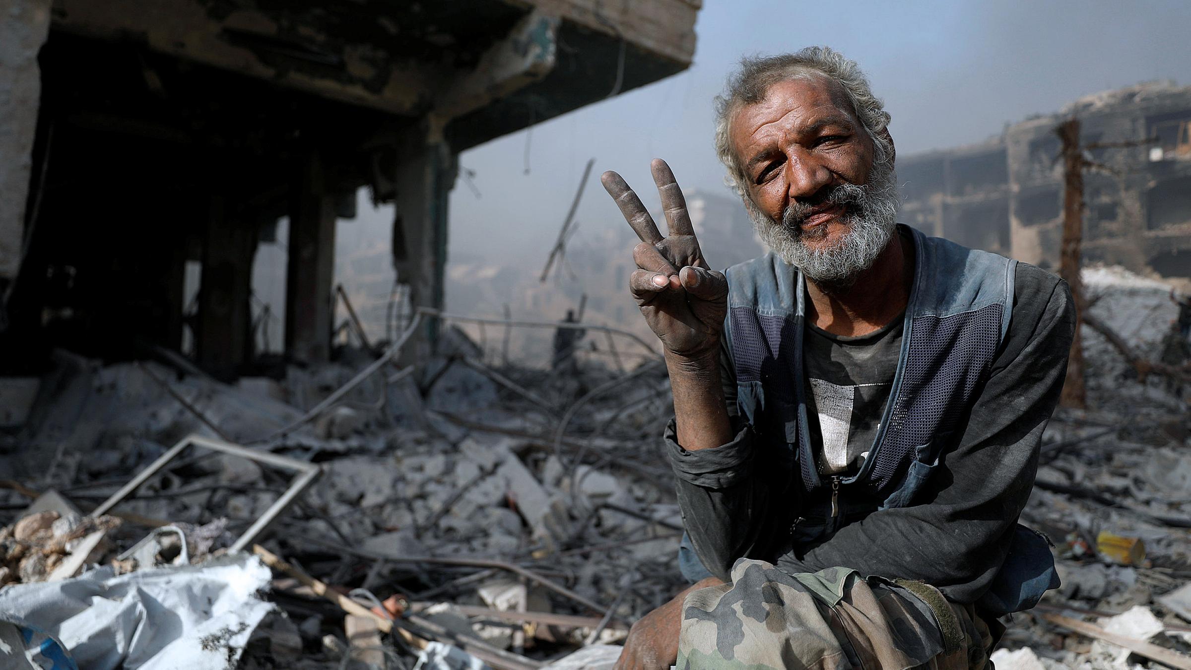 Archiv: Ein Mann zwischen den Trümmern eines zerstörten Gebäudes in Syrien, aufgenommen am 21.05.2018  in Al-Hajar Al-Aswad