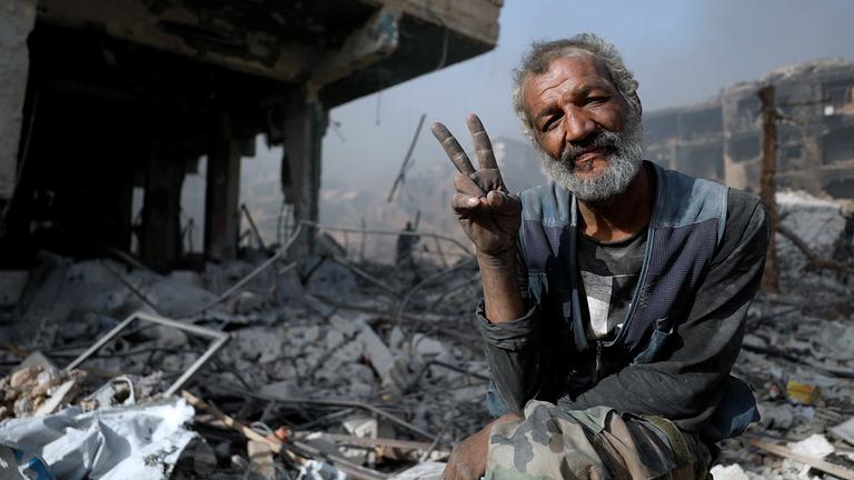Archiv: Ein Mann zwischen den Trümmern eines zerstörten Gebäudes in Syrien, aufgenommen am 21.05.2018  in Al-Hajar Al-Aswad
