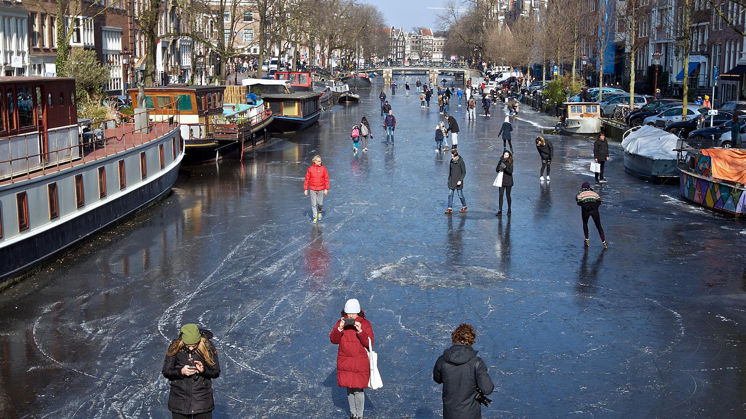 Menschen gehen auf der zugefrorenen Prinsengracht in Amsterdam, aufgenommen am 02.03.2018