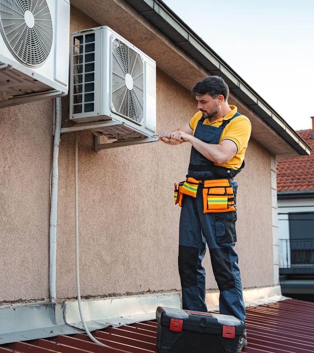Techniker installiert Klimaanlage auf Dach.