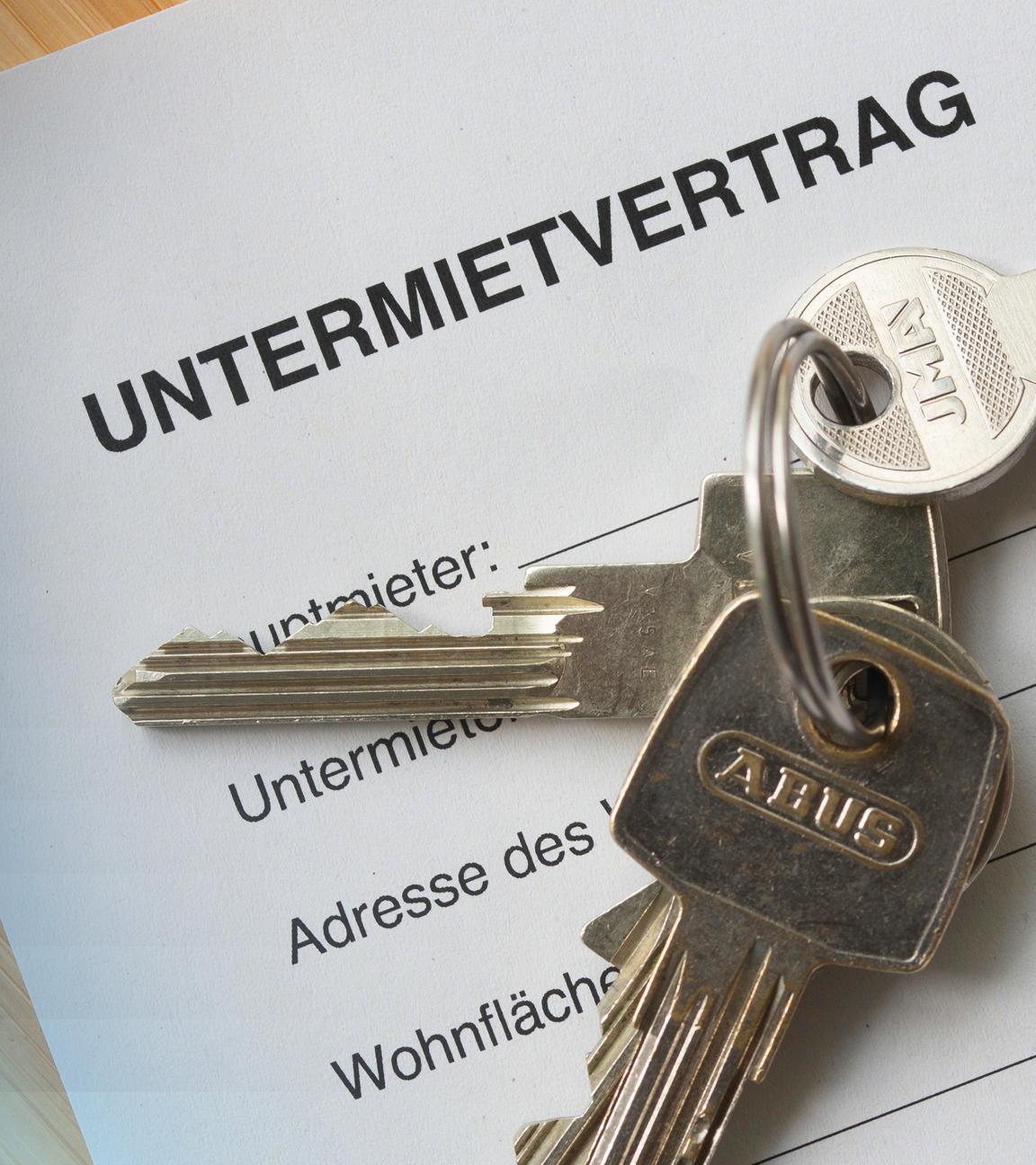 Schlüssel die auf einem nicht ausgefülltem Untermietvertrag liegen. 