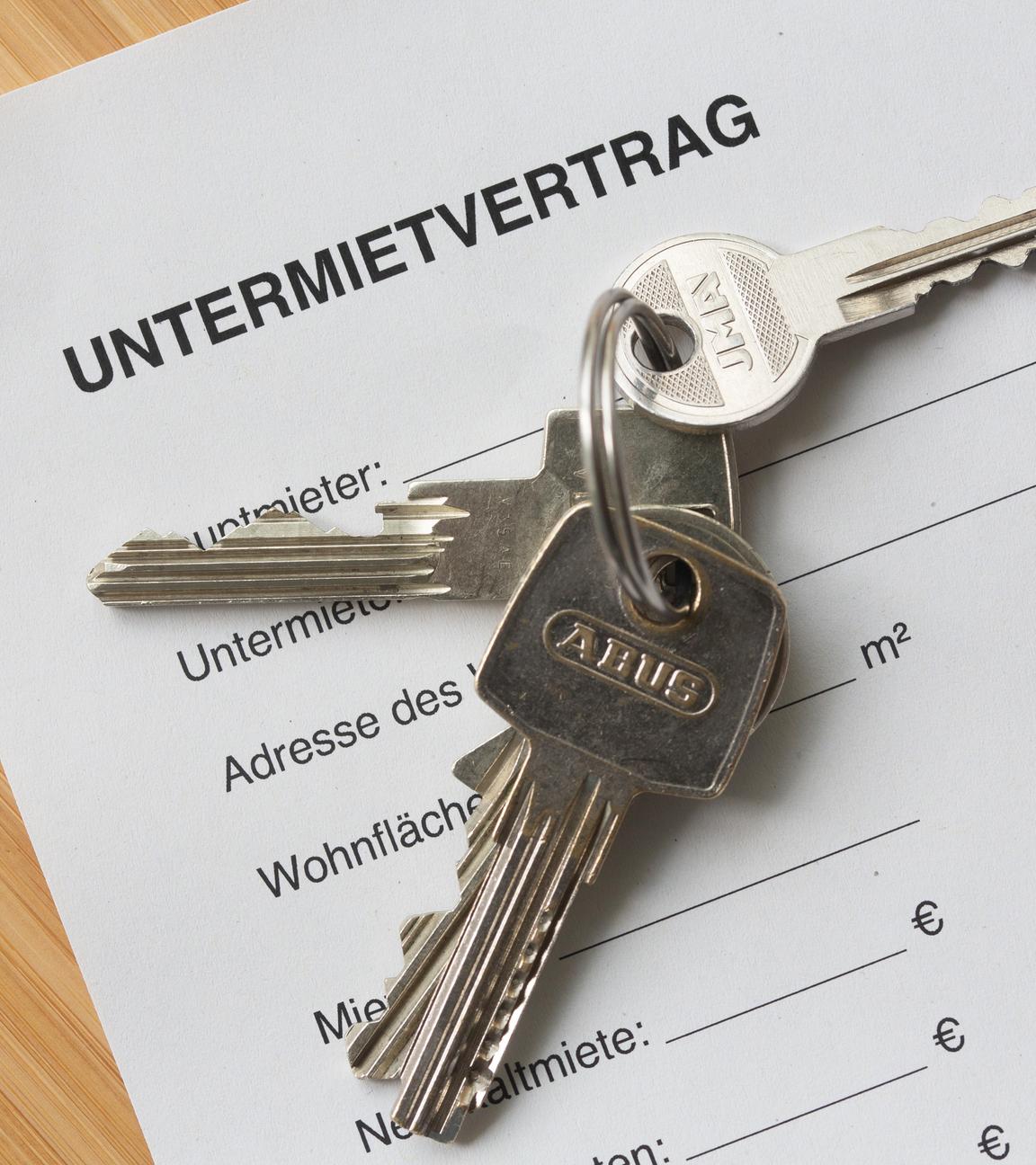 ILLUSTRATION - 17.09.2025, Berlin: Ein Untermietvertrag liegt zusammen mit Wohnungsschlüsseln auf einem Tisch. Das oberste deutsche Zivilgericht prüft, ob ein Vermieter seinem Mieter kündigen kann, wenn der die Wohnung «gewinnbringend» untervermietet.