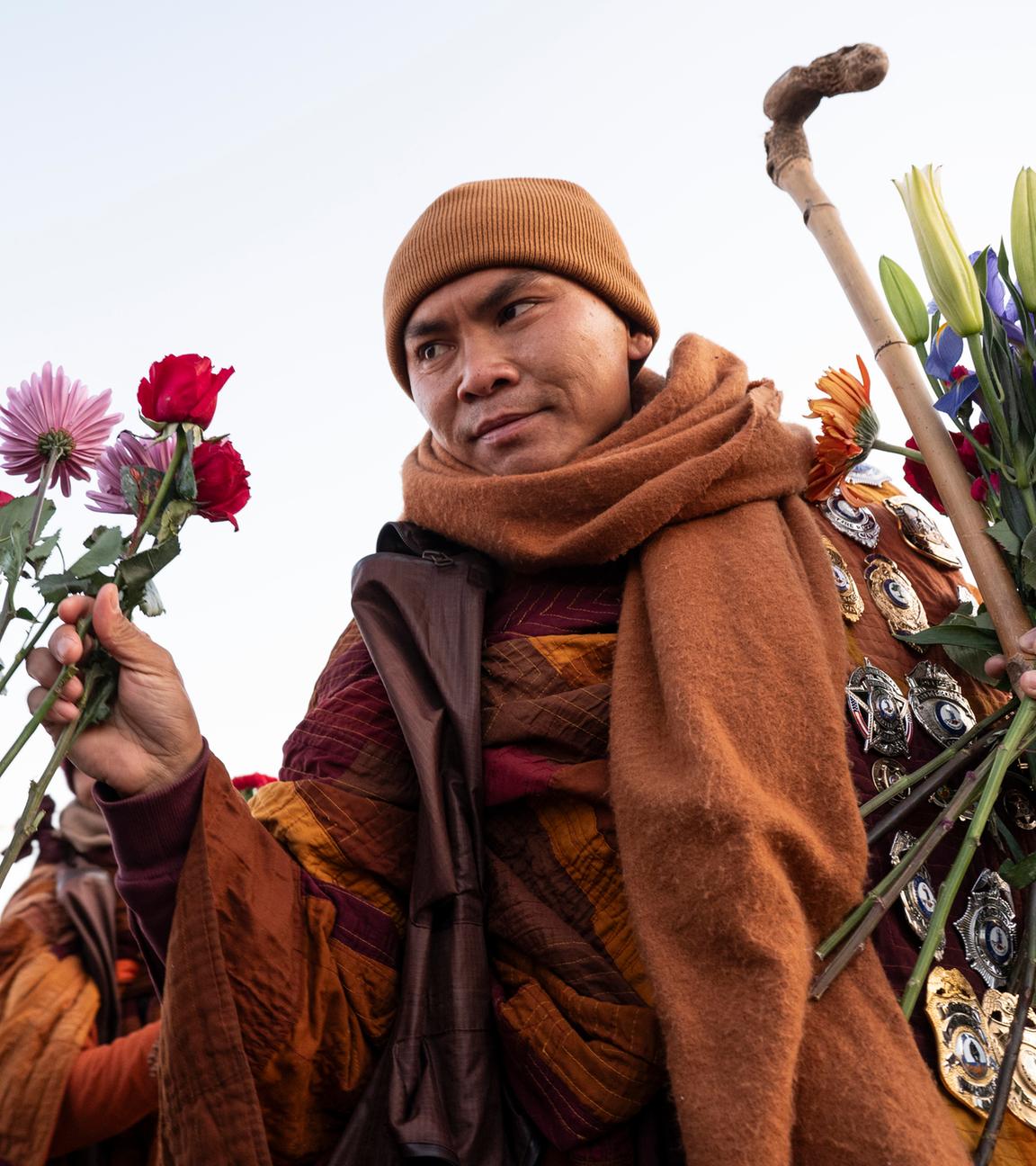 Der ehrwürdige Bhikkhu Pannakara nimmt eine Blume als Opfergabe entgegen, während er die Theravada-buddhistischen Mönche beim Friedensmarsch in Woodbridge, Virginia, USA