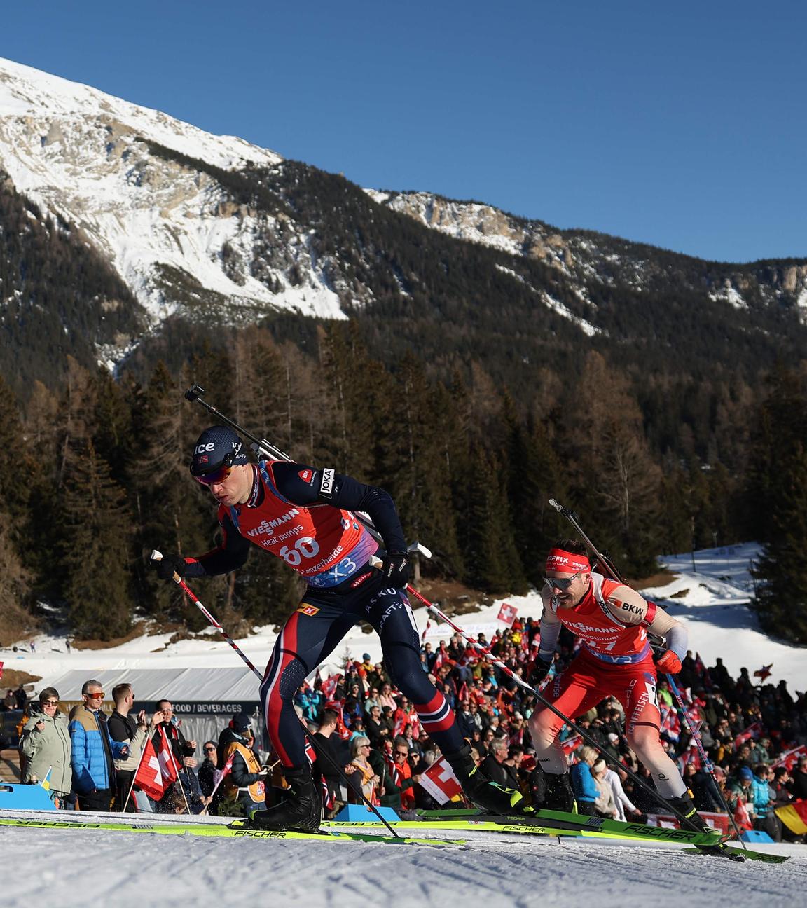 Norwegens Tarjei Bö und der Schweizer Joscha Burkhalter in Aktion beim 10 km Sprint in Lenzerheide am 15.02.2025.