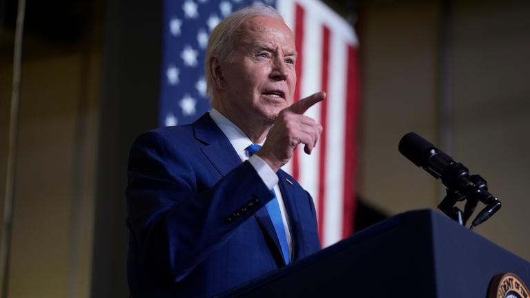 US-Präsident Joe Biden steht mir erhobenem Zeigefinger am Rednerpult im Hintergrund hängt eine US-Flagge.