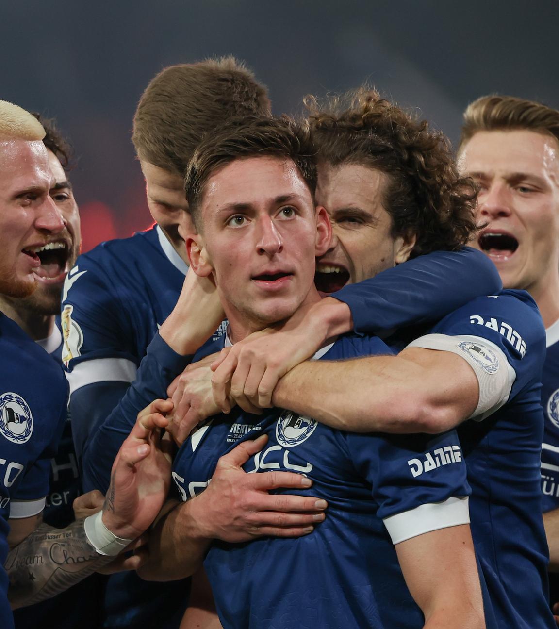 DFB-Pokal, Arminia Bielefeld - Werder Bremen, Viertelfinale: Bielefelds Torschütze Marius Wörl (Mitte) feiert seinen Treffer zum 1:0 mit Louis Oppie (l.) und Mael Corboz (3.v.r).