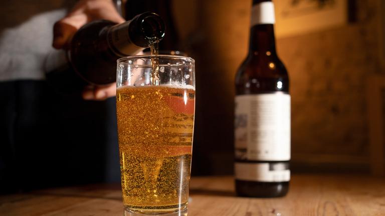 Bier wird in ein Glas geschüttet.