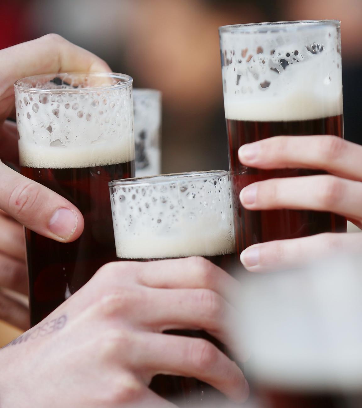 Düsseldorf: Gäste stoßen an einem Tisch im Außenbereich eines Lokals mit Altbier an.