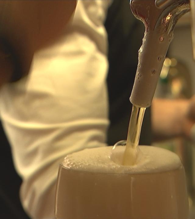 Auf dem Bild ist ein Bierglas unter dem Zapfhahn zu sehen.