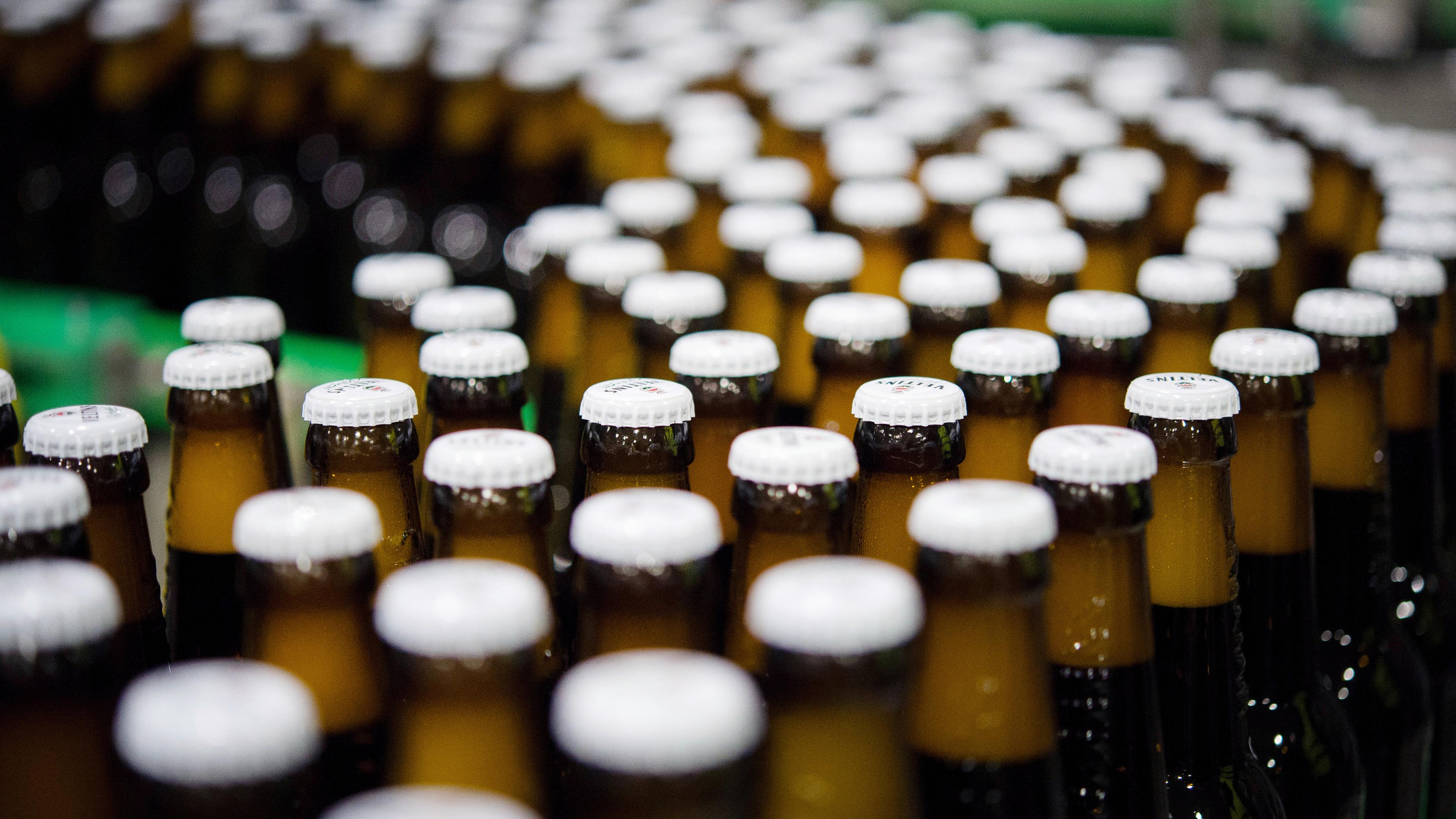 Symbolbild:  Bierflaschen mit Kronkorken laufen durch die Produktion der Veltins-Brauerei in Meschede-Grevenstein über die Förderbänder einer Befüllungsanlage