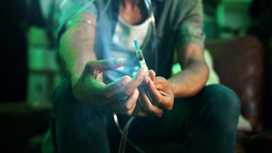 Ein Fixer hält eine Spritze mit Fentanyl in den Händen, Nahaufnahme