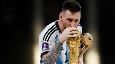 Lionel Messi streckt den WM-Pokal 2022 in die Höhe. 