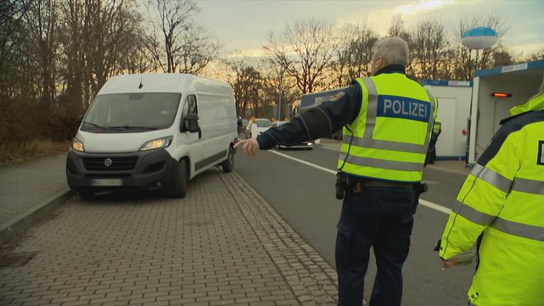 Auf dem Bild sieht man einen Polizisten der eine Verkehrskontrolle durchführt.