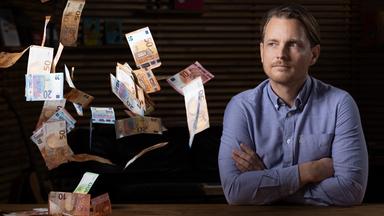 Junger Mann schaut in die Kamera, Geld fliegt umher.