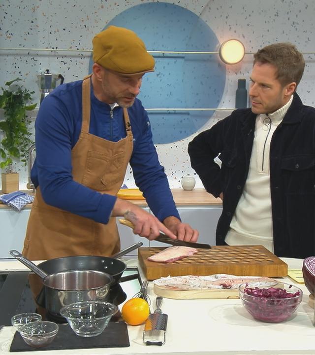 Grillexperte Carsten Goms bereitet neben Florian Weiss eine Entenbrust vor.