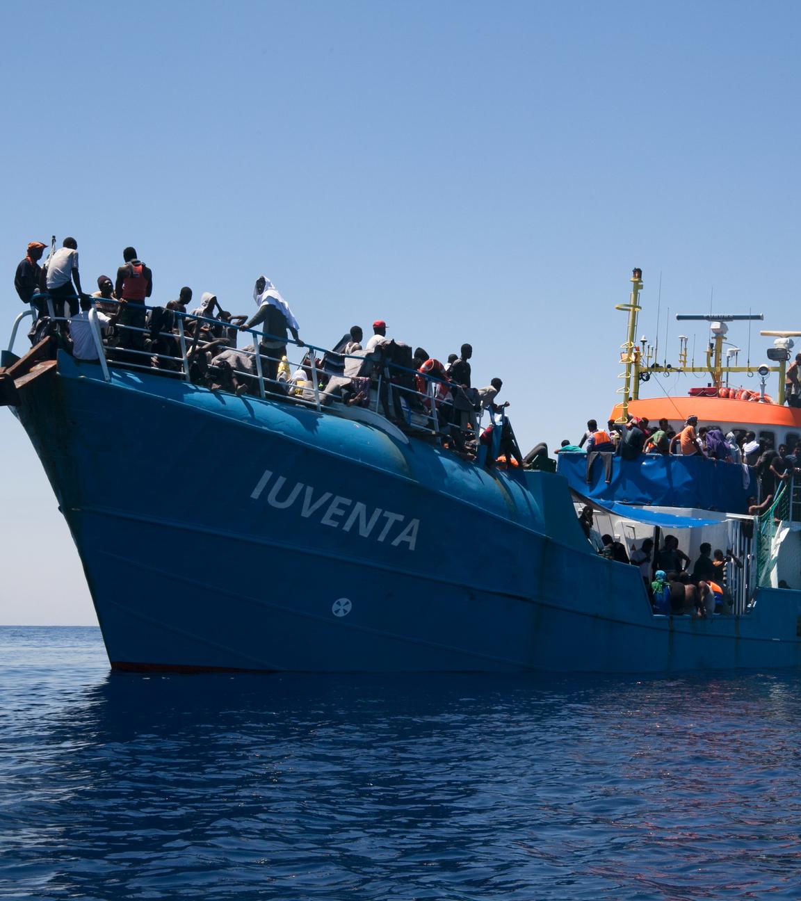 "I"Iuventa": Ein mit Menschen vollbesetztes Frachtschiff mit dem Namenszug „Iuventa“, von einem anderen Boot aus fotografiert, liegt im Mittelmeer.