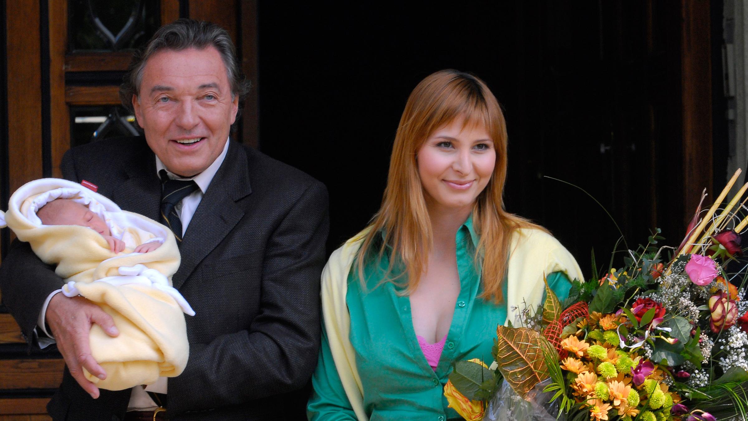 Karel Gott verlässt am 6. Mai 2006 mit seiner neugeborenen Tochter Charlotte Ella und ihrer Mutter Ivana (r.) das Krankenhaus