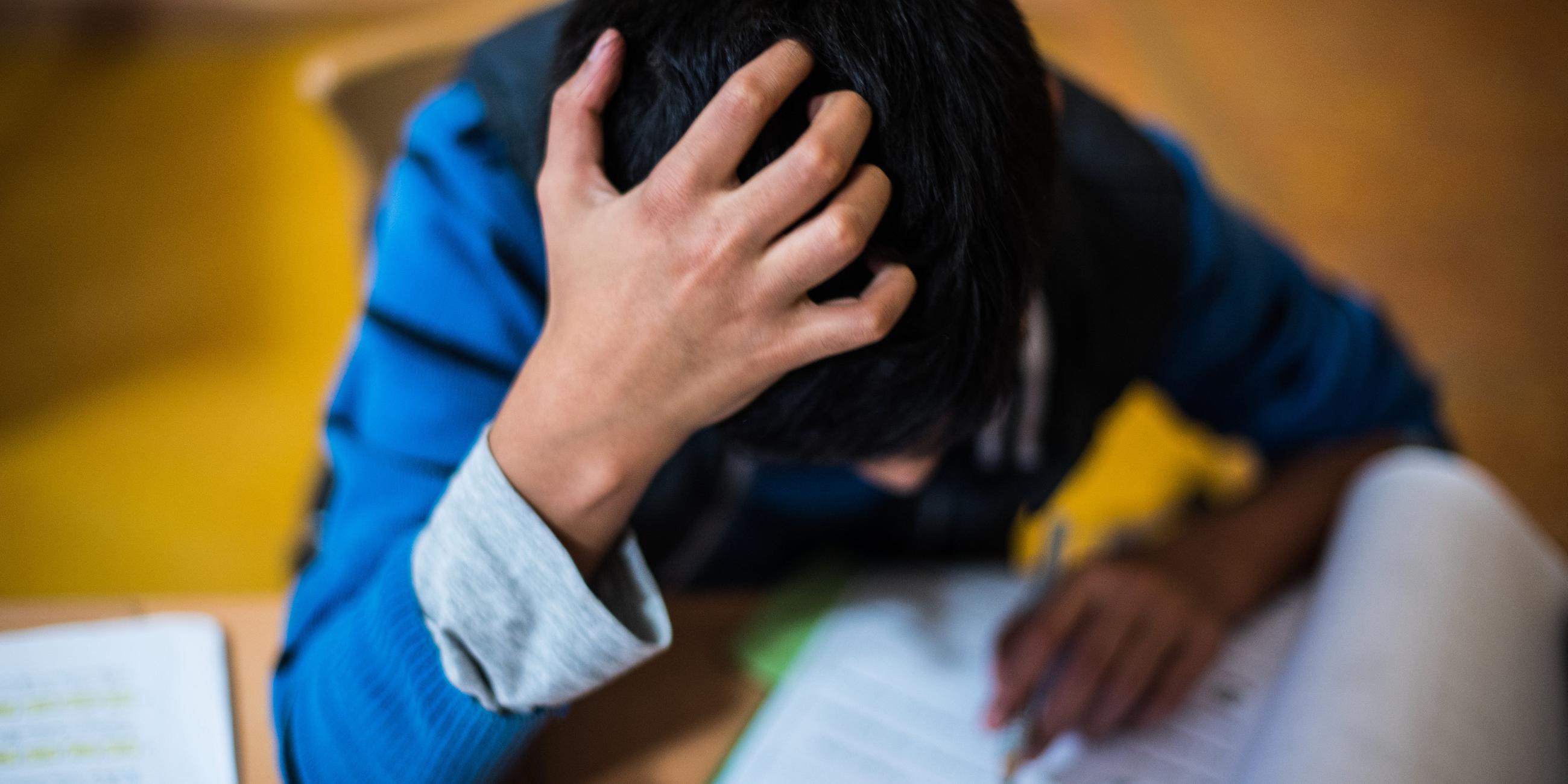 Ein Junge sitzt in der Hausaufgabenhilfe an seinen Schularbeiten.
