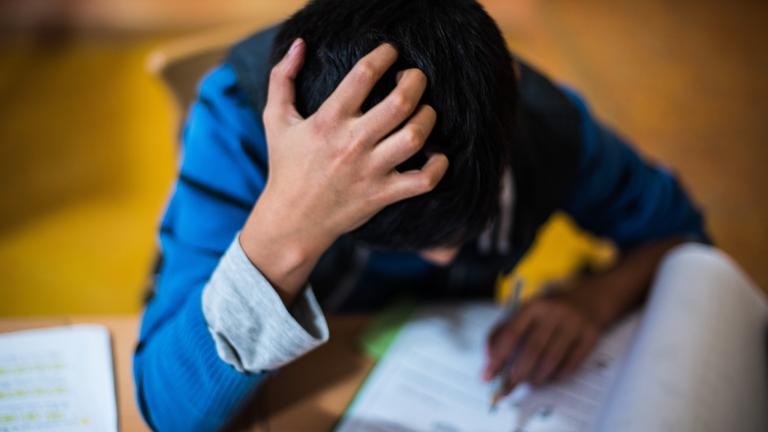 Ein Junge sitzt in der Hausaufgabenhilfe an seinen Schularbeiten.