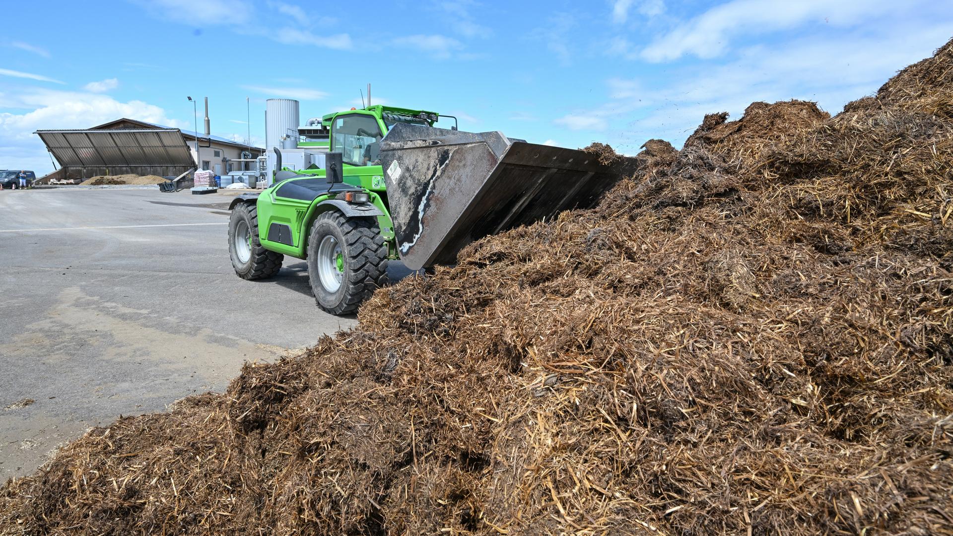 Traktor mit Biomasse in Biogasanlage