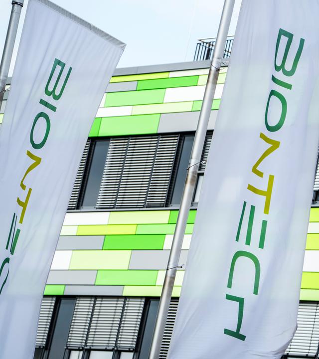 Die Flaggen des Pharma-Unternehmens Biontech flattern vor der Firmenzentrale im Wind am 21.04.2026 in Mainz.