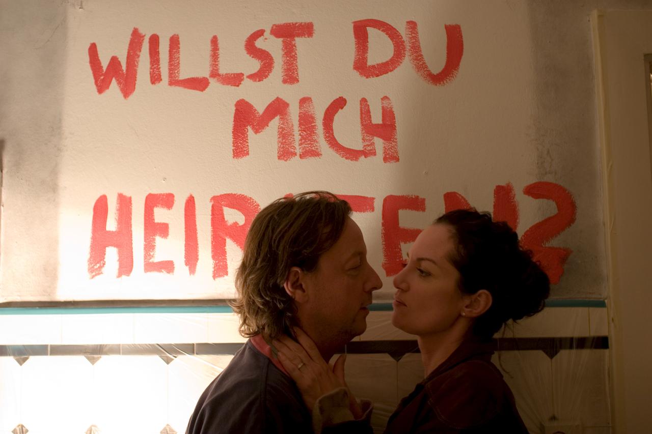 Niko Brix (Matthias Brandt) macht Kommissarin Jana Winter (Natalia Wörner), beim Renovieren der Küche einen Heiratsantrag. Im Hintergrund steht "Willst du mich heiraten" an der Wand.