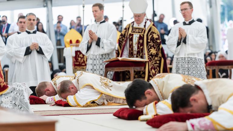 Priester liegen auf dem Boden, während sie im Rahmen einer von der Priesterbruderschaft St. Pius X. (SSPX) organisierten Messe die Bischofsweihe empfangen