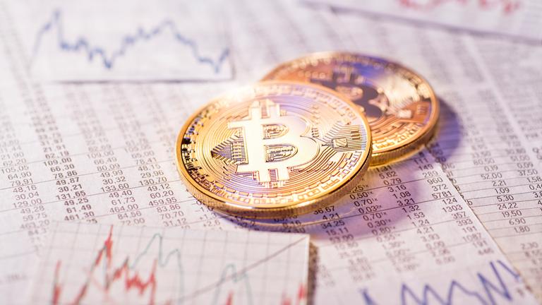 Bitcoins mit Aktienkursen im Hintergrund