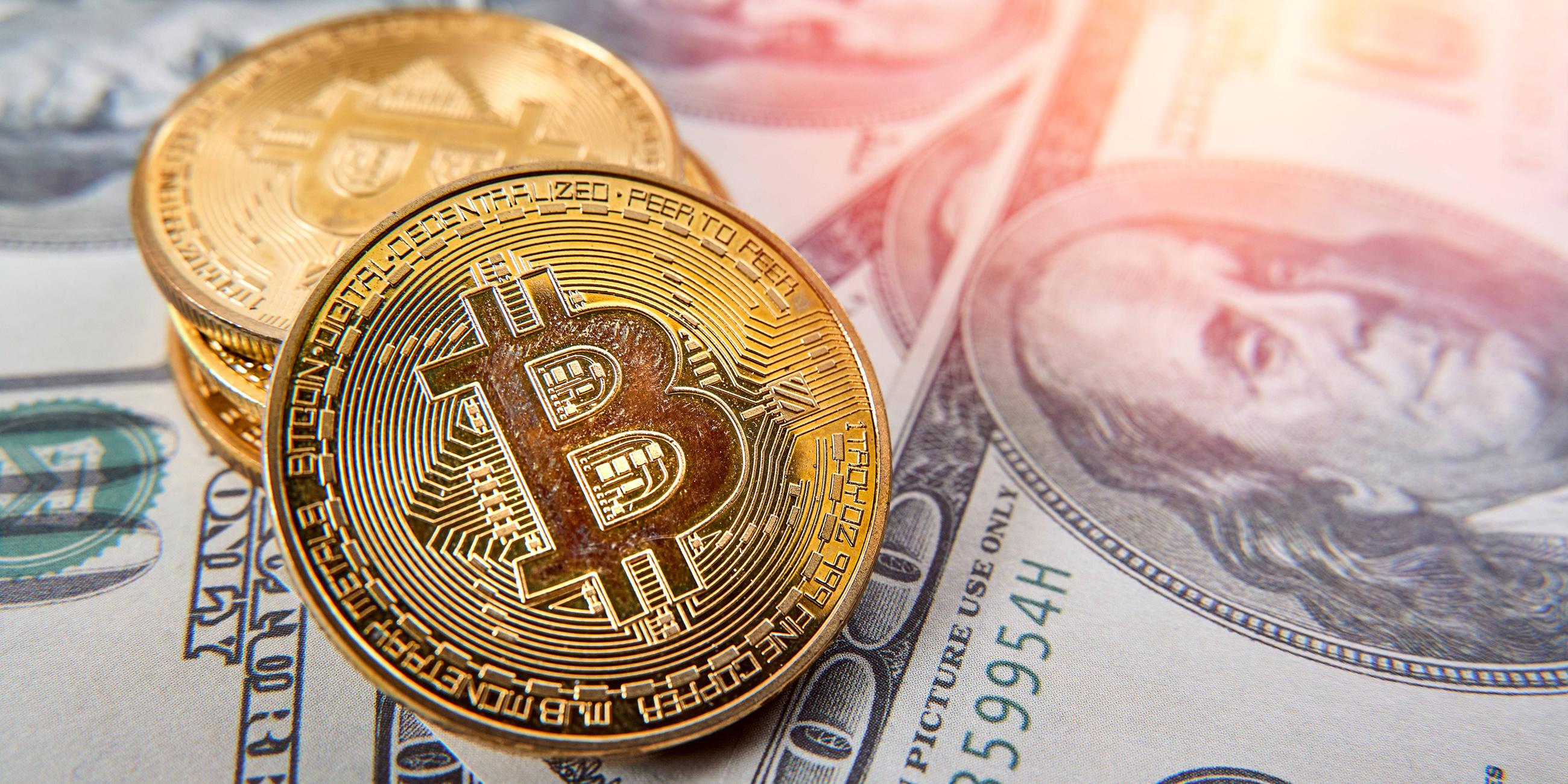 Bitcoin-Goldmünzen auf US-Dollar-Geldscheinen
