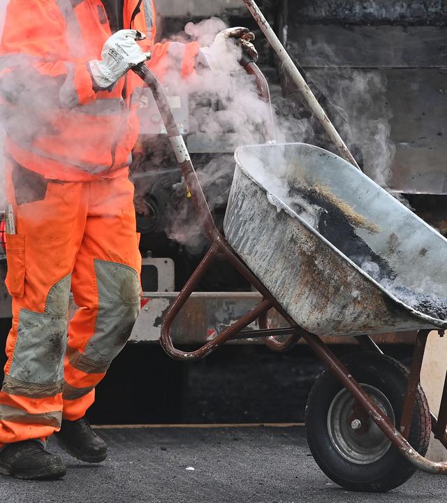 Straßenbauer bei der Arbeit mit einer Schubkarre