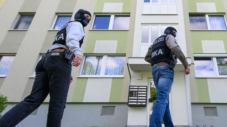 Polizisten vom Bundeskriminalamt (BKA) gehen zu einer Durchsuchung in ein Mehrfamilienhaus