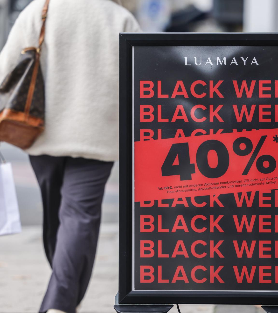 Vor dem Eingang eines Geschäftes wird für Rabatte am Black Friday geworben.