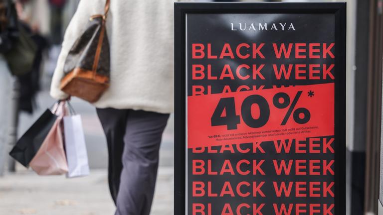 Vor dem Eingang eines Geschäftes wird für Rabatte am Black Friday geworben.