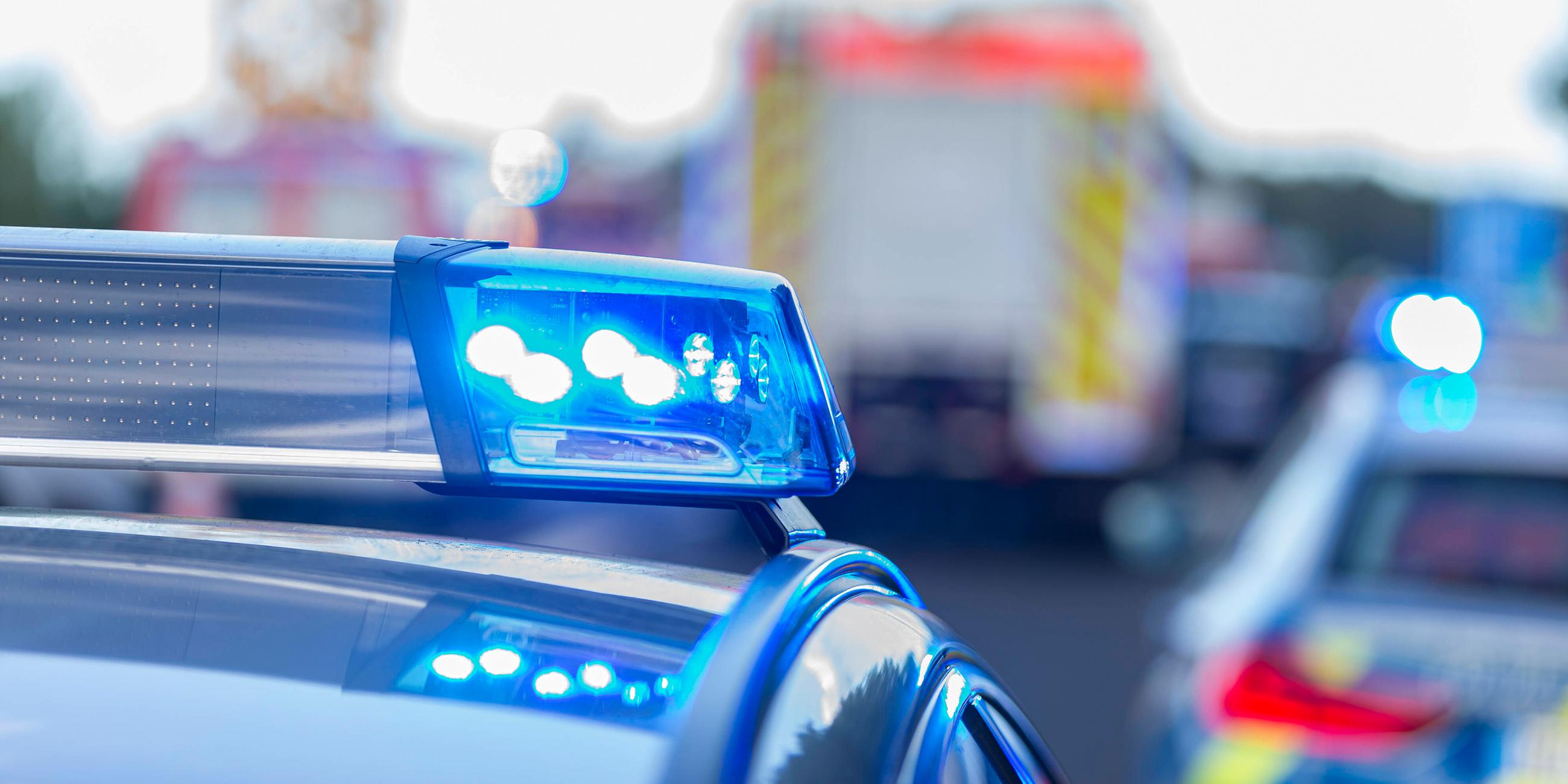 Blaulichtfahrzeug mit Krankenwagen im Hintergrund