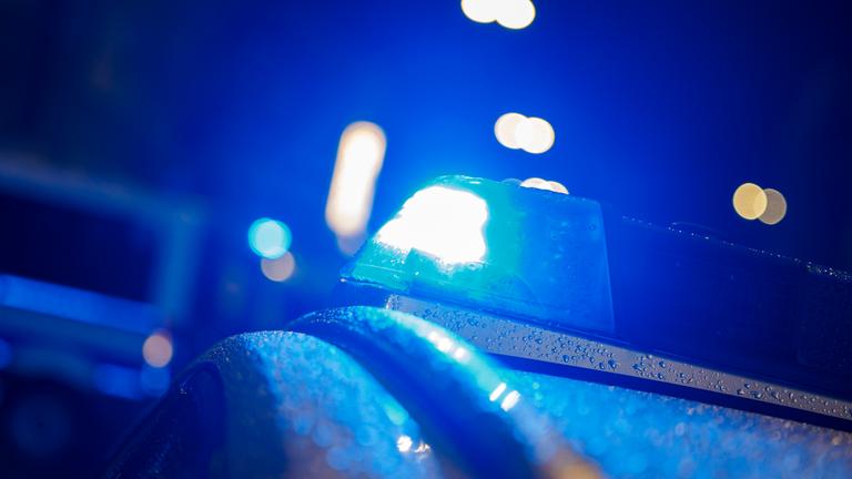 Das Blaulicht eines Polizeifahrzeugs leuchtet blau bei einem Einsatz.