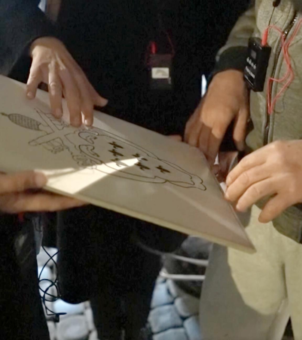 Zwei Hände, die ein Kunstwerk ertasten.