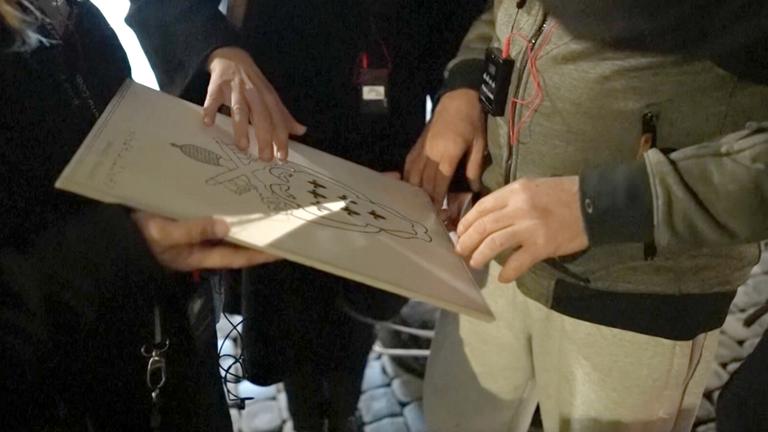 Zwei Hände, die ein Kunstwerk ertasten.