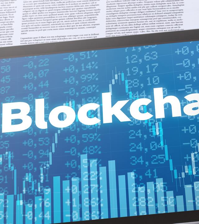 Tablet mit Schrift "Blockchain" auf Finanzdokumenten neben Taschenrechner