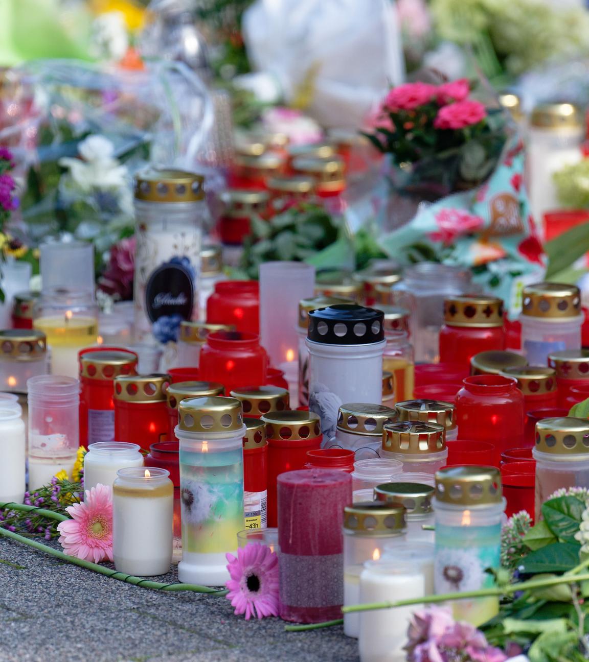 Blumen und Kerzen in Gedenken an die Opfer von Solingen liegen an einer Kirche
