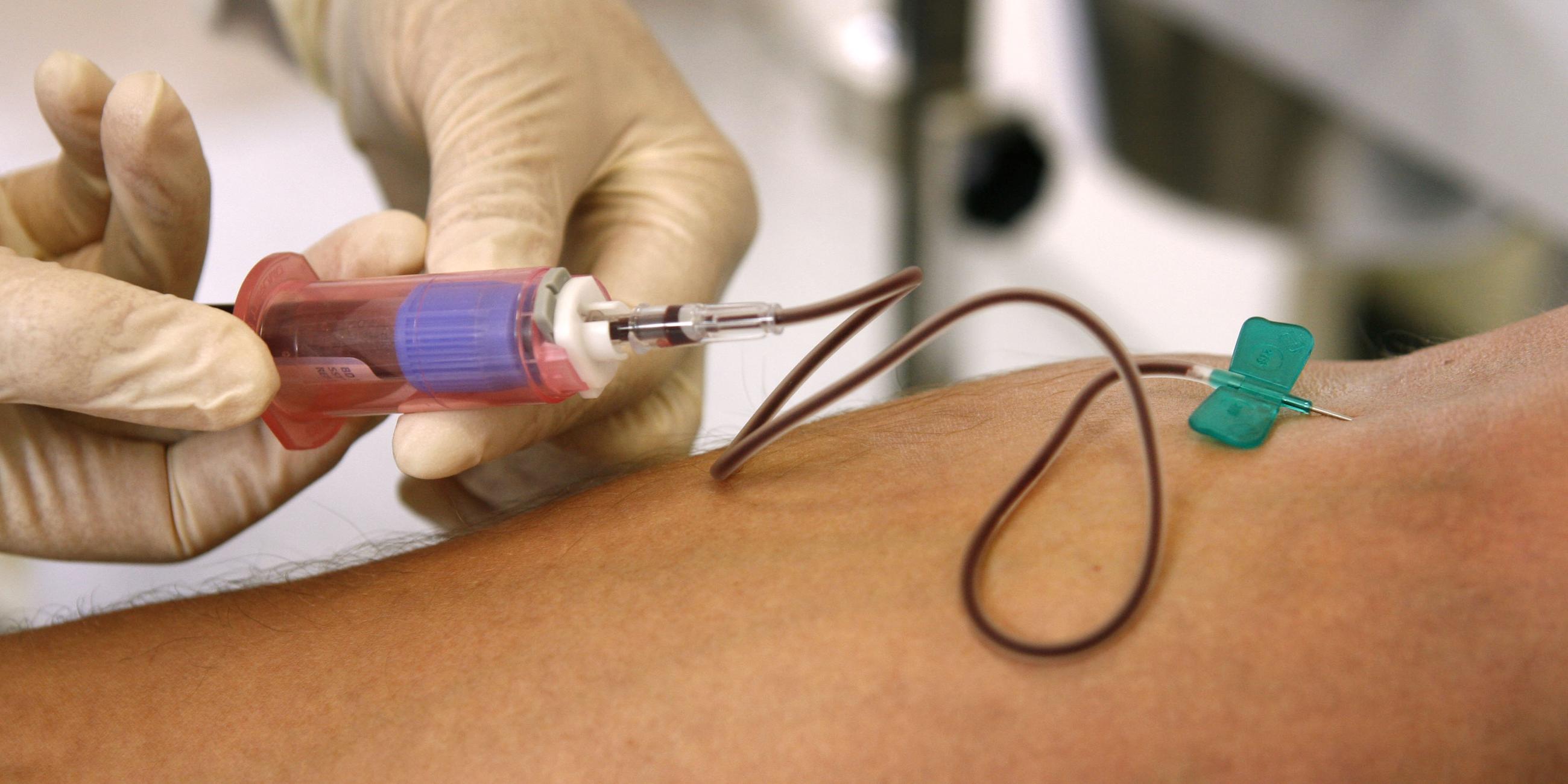 Einem Patienten wird am Arm Blut abgenommen.