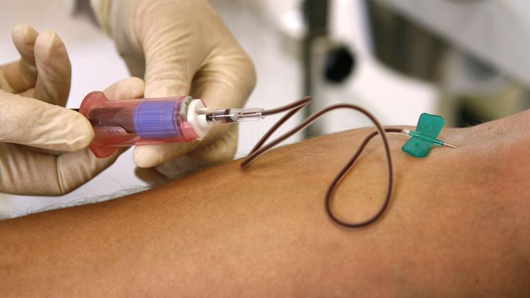 Einem Patienten wird am Arm Blut abgenommen.