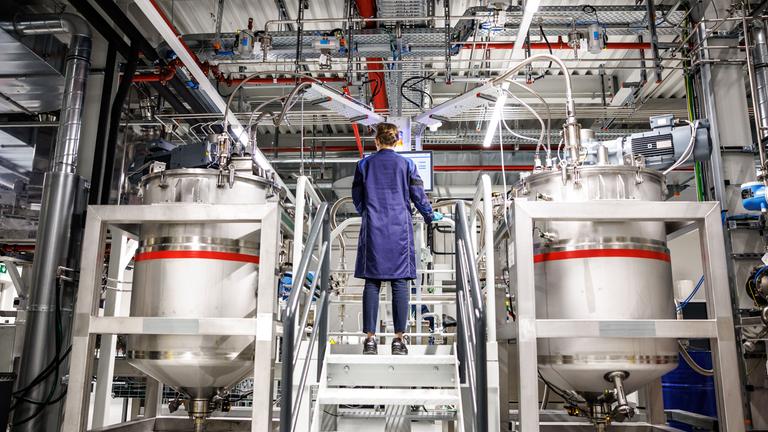 Bayern, Vaterstetten: Desiree Grießl, zuständig für die Technologie-Entwicklung Elektrode bei BMW, steht bei einem Presserundgang durch das BMW Kompetenzzentrum für Batteriezellfertigung Parsdorf (Cell Manufacturing Competence Centre, CMCC) in einer Werkshalle im Bereich "Dosieren und Mischen" zwischen zwei Mischbehältern, in denen die Batteriepaste ("Slurry") gemischt wird.