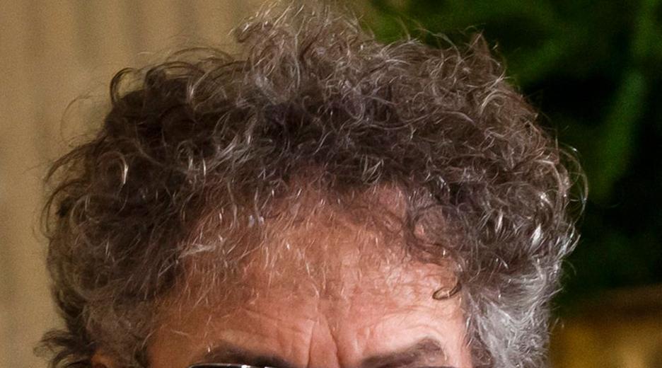 Bob Dylan mit Anzug, schwarzer Sonnenbrille und Fliege. 