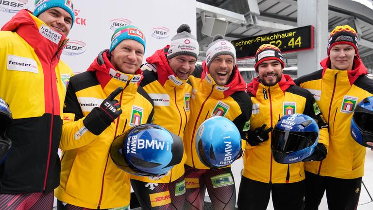 Innsbruck, 29.11.2025: Die Sieger Johannes Lochner und Georg Fleischhauer, die Zweitplatzierten Francesco Friedrich und Alexander Schaller sowie die Drittplatzierten Adam Ammour und Tim Becker feiern nach dem Zweierbobrennen beim Bob-Weltcup.