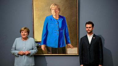 Die ehemalige deutsche Bundeskanzlerin Angela Merkel (links) und der deutsch-französische Künstler Jeremie Queyras (rechts) stehen neben seinem Gemälde „Porträt der ehemaligen Bundeskanzlerin Angela Merkel“ anlässlich dessen Enthüllung im Bode-Museum in Berlin.