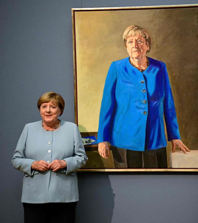 Die ehemalige deutsche Bundeskanzlerin Angela Merkel (links) und der deutsch-französische Künstler Jeremie Queyras (rechts) stehen neben seinem Gemälde „Porträt der ehemaligen Bundeskanzlerin Angela Merkel“ anlässlich dessen Enthüllung im Bode-Museum in Berlin.