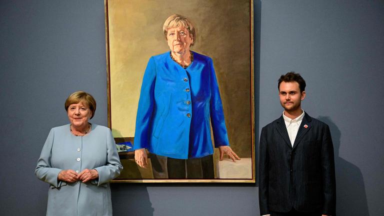 Die ehemalige deutsche Bundeskanzlerin Angela Merkel (links) und der deutsch-französische Künstler Jeremie Queyras (rechts) stehen neben seinem Gemälde „Porträt der ehemaligen Bundeskanzlerin Angela Merkel“ anlässlich dessen Enthüllung im Bode-Museum in Berlin.