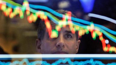 Broker an der New Yorker Börse beim Betrachten des Börsenkurses 