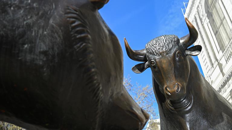 Die Bronzefiguren von Bulle (r) und Bär, Symbole für den Börsenauf- und abschwung, stehen auf dem Platz vor der Börse. 