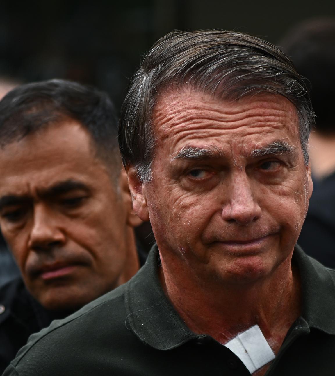 Eine Aufnahme von Bolsonaro nachdem er das Krankenhaus verlässt. Er schaut ernst in die Kamera.